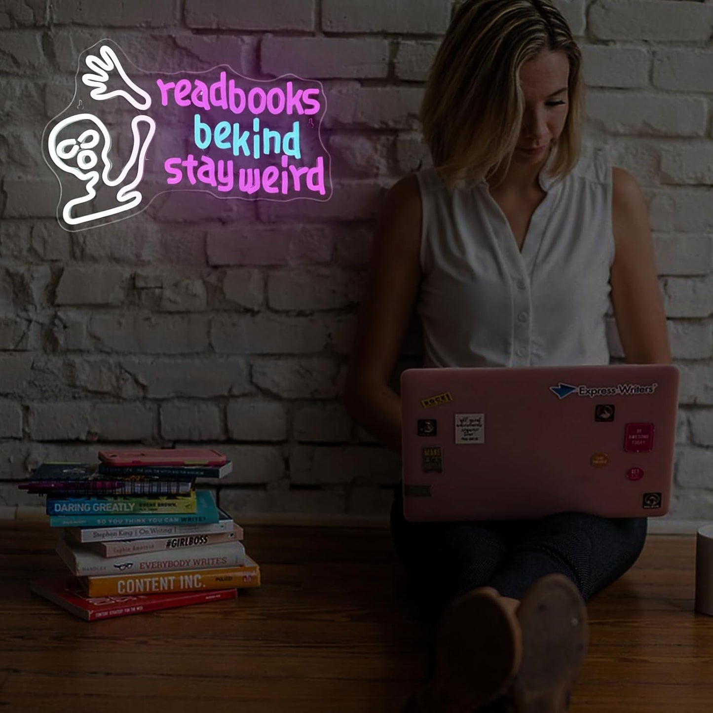 Waving alien neon sign with the phrase "Read Books Be Kind Stay Weird" glowing in LED lights