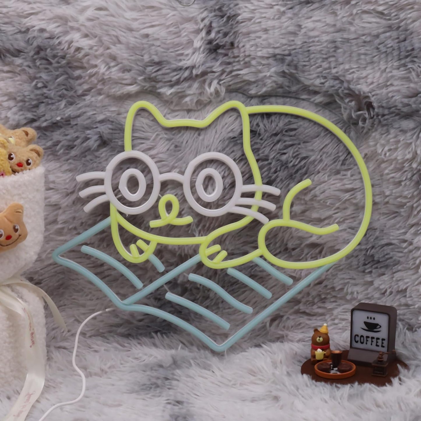 Neon sign of cat lying down and reading a book