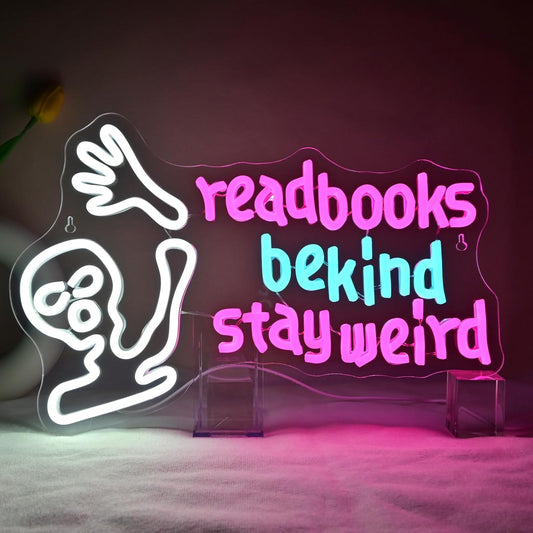 Waving alien neon sign with the phrase "Read Books Be Kind Stay Weird" glowing in LED lights

