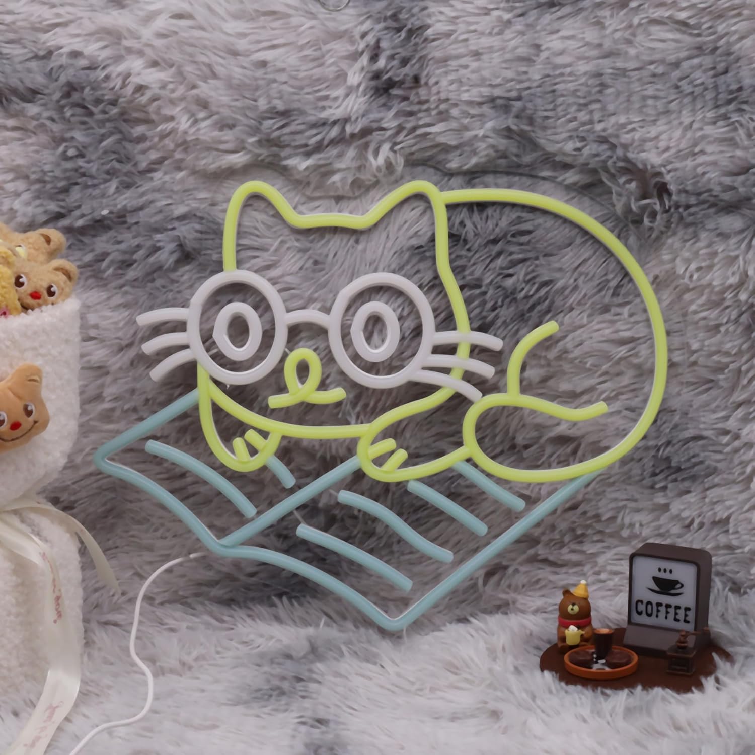 Neon sign of cat lying down and reading a book