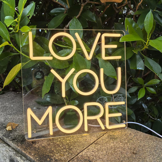 LED neon sign with the words ‘Love You More’ in bright script – romantic wall decor